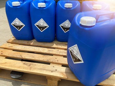 Corrosive chemical symbols on a blue chemical tank, dangerous products in the industry