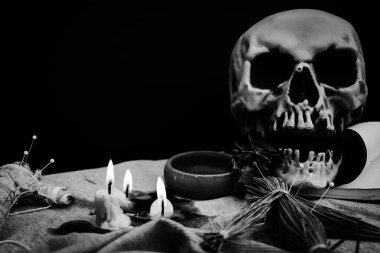 Eldeki lanetli bebek ve kafatası arka planı, din ve inanç