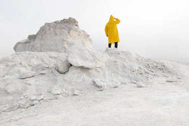 Adam sisli beyaz bir avcı dağında kayboldu. Sarı yağmurluk giyiyordu.