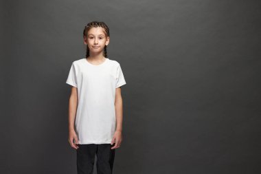 Logonuz için yeri olan beyaz tişört giyen ya da stüdyoda gri arka planda tasarım yapan kız.