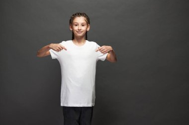 Logonuz için yeri olan beyaz tişört giyen ya da stüdyoda gri arka planda tasarım yapan kız.