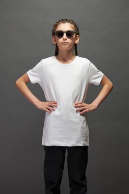 Logonuz için yeri olan beyaz tişört giyen ya da stüdyoda gri arka planda tasarım yapan kız.