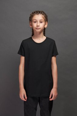 Logonuz için yeri olan siyah tişört giyen çocuk ya da gri arka planda stüdyoda tasarım yapan kız.