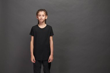 Logonuz için yeri olan siyah tişört giyen çocuk ya da gri arka planda stüdyoda tasarım yapan kız.