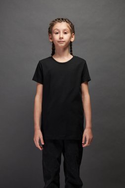 Logonuz için yeri olan siyah tişört giyen çocuk ya da gri arka planda stüdyoda tasarım yapan kız.