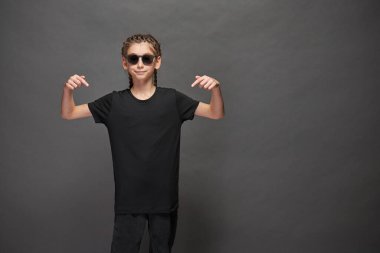 Logonuz için yeri olan siyah tişört giyen çocuk ya da gri arka planda stüdyoda tasarım yapan kız.