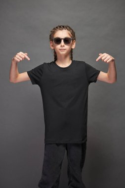 Logonuz için yeri olan siyah tişört giyen çocuk ya da gri arka planda stüdyoda tasarım yapan kız.