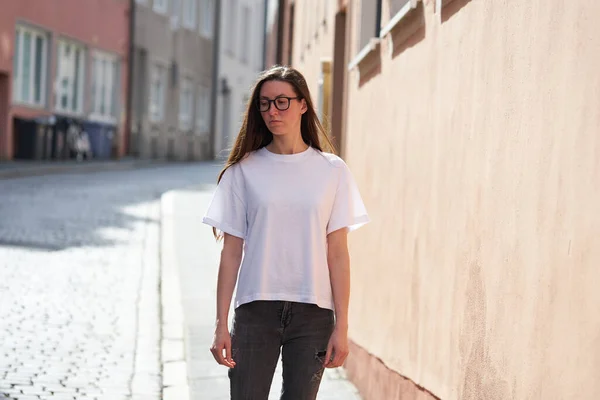 城市里身穿白色空白T恤 戴着眼镜的女性 — 图库照片
