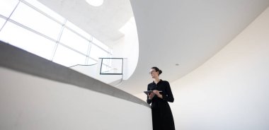 Minimalist ofis çalışma alanında tablet bilgisayar kullanan kadın