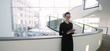 Minimalist ofis çalışma alanında tablet bilgisayar kullanan kadın