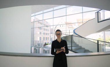 Minimalist ofis çalışma alanında tablet bilgisayar kullanan kadın