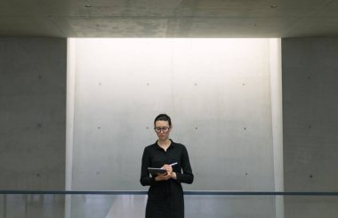 Minimalist ofis çalışma alanında tablet bilgisayar kullanan kadın