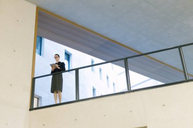 Minimalist ofis çalışma alanında tablet bilgisayar kullanan kadın