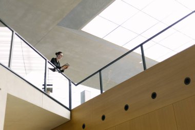 Minimalist ofis çalışma alanında tablet bilgisayar kullanan kadın