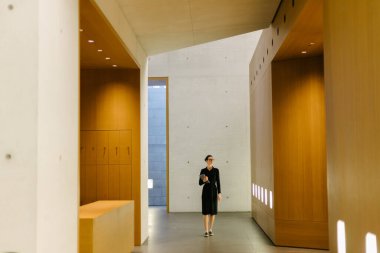 Ofiste elinde tabletle dolaşan bir iş kadını.