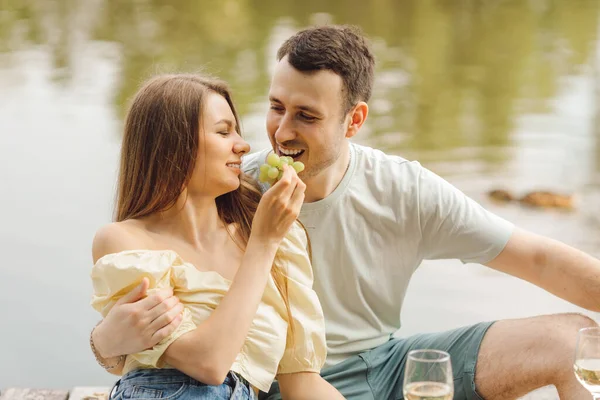 Erkek kız arkadaşına sarılır ve kadın onu doğadaki romantik piknik sırasında üzümle besler. Mutluluk ve sükunet. Dinlen ve eğlen. Süper gün. Romantik ilişkiler. Şefkat ve özen. 