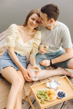 Aşık mutlu çift piknik sırasında terasta şarap içer. Mutluluk ve sükunet. Hayatın güzel anları. Romantik ilişkiler. Doğru yaşam biçimi. Birbirimizi kolluyoruz.. 