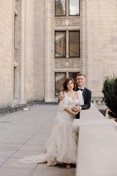 在城市混凝土建筑的背景下 年轻夫妇新娘和新郎穿着婚纱的照片 祝你结婚快乐 — 图库照片