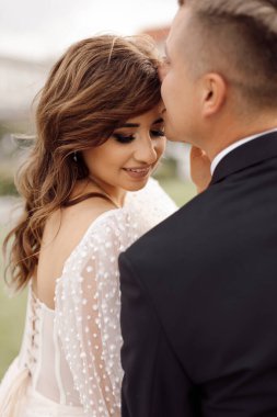 Düğün günü portresi. Romantik nazik dokunuş, aşk ve mutlu evlilik kavramı. Genç çiftlerin dokunaklı tavırları. Gelin ve damadın portresi. Yaşam tarzı, fotoğraf. Arka görünüm