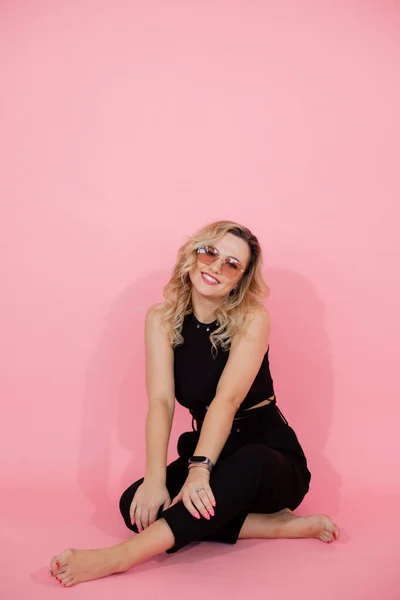 Mooie Jonge Vrouw Zit Roze Achtergrond Vloer Benen Gekruist Studio — Stockfoto