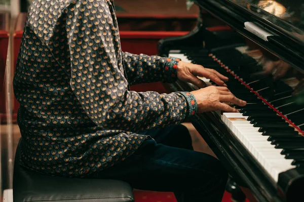 ピアノやグランドピアノの鍵盤でメロディーを演奏する大人の老人の手 クローズアップライフスタイルの写真 — ストック写真