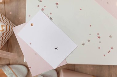 Pembe zarf içinde boş beyaz kartın fotoğrafı parlayan yıldızlar, vaucher ve hediye sertifikasıyla izole edilmiş ahşap bir arka plan.. 