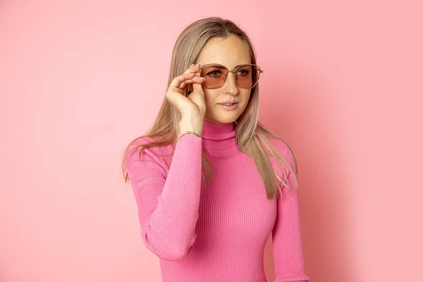 머리가긴 여성의 사진이다 상점에서 선글라스를 근처에 시선을 돌리고 분홍색 — 스톡 사진