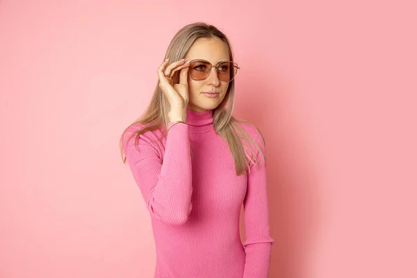 머리가긴 여성의 상점에서 선글라스를 선택하고 근처에 고개를 돌리는 분홍색 그려진 — 스톡 사진