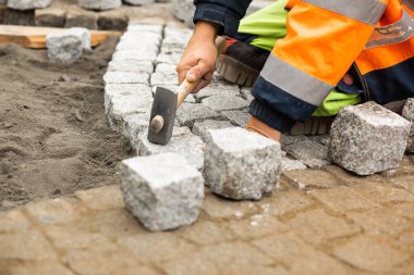 Kaldırım taşlarıyla asfalt döşeme işi. Elinde inşaat malzemeleri, beton ürünleri, yol ya da kaldırım inşaatı sanayisi olan tanınmayan kişi.
