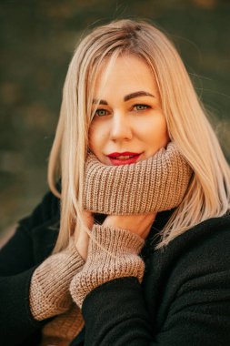  Güzel, güzel, yün kazaklı, sırıtan bir sarışını düşünmek ellerini yüksek boyunlu süveterle ısıtıyor. Güzel kadınlar. Sonbahar portresi. Eğlence ve seyahat. Yaşam biçimi. 