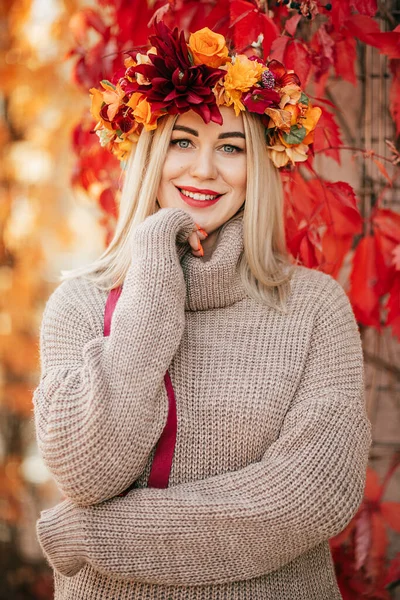Portret Uśmiechniętej Blondynki Swetrze Wieńcu Wielobarwnych Kwiatów Liści Stojących Tle — Zdjęcie stockowe