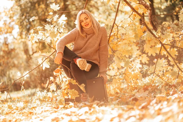 Urocza Zadowolona Blondynka Wygodnym Swetrze Siedzi Lesie Walizce Słoneczny Jesienny — Zdjęcie stockowe