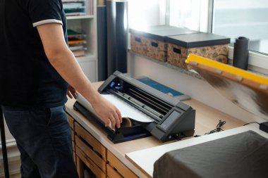 Kırpılmış işçi tarafı sticker kesme uygulaması vinil film zarı çıkartması kullanıyor. Uygulama tasarımı yazdırılıyor.