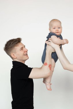 Sevinçli bir genç adam, baba, kucağında küçük şirin bir bebek, şefkatli kadın elleri. Taşıyıcı annelik, bekleyen çocuk.