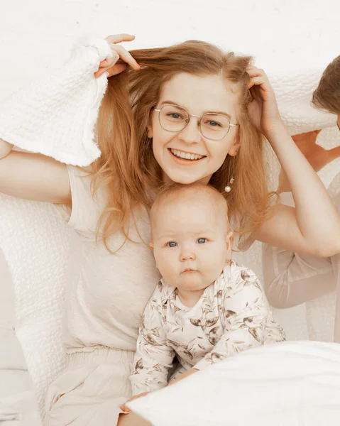 Portrét veselé usměvavé šťastné ženy matka a dítě přikryté bílým ručníkem dítě. Ochrana bezpečnosti. Péče o pleť, hygiena — Stock fotografie