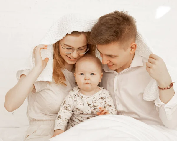 Retrato de alegre sorrindo feliz família coberto toalha branca. Mulher, homem, bebé, abraço. Adopção, protecção. Fechar — Fotografia de Stock