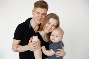 Mutlu eşlerin, ebeveynlerin, ailenin, kolunda dövmesi olan adamın, kadının, çocuğun stüdyo fotoğrafları. Zıplayan goller. Kapat.