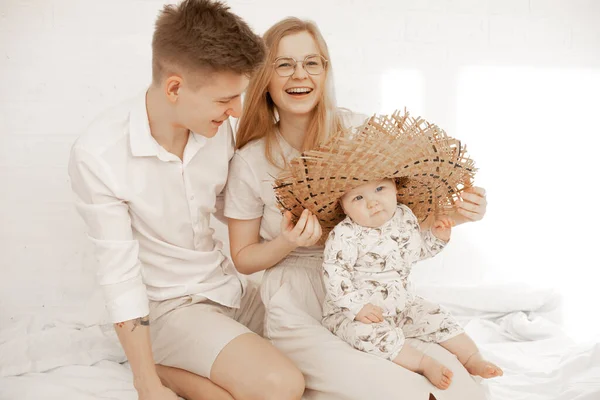 Portrét šťastné rodiny, společný čas, hraní, radování. Nosí velký slaměný klobouk. Narozeninová oslava na domácí oslavě. — Stock fotografie