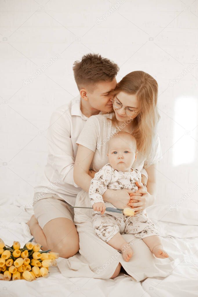 Vertical portrait happy family, spending time together, kissing, embracing. Happy mother day celebration, yellow tulips