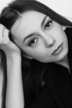 Siyah beyaz portre. Uzun siyah saçlı, siyah ceketli, çekici bir kadın modeli..