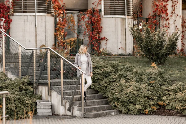 Retrato de una mujer rubia hermosa caminando escaleras de piedra sosteniendo barandilla, expresión después del parque turístico, cerca del museo del edificio —  Fotos de Stock