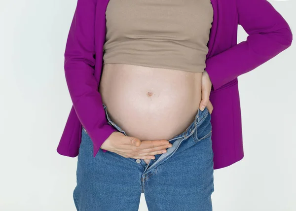 有白色背景的怀孕的腹部，无法辨认的妇女用双手支撑怀孕的腹部，怀孕期间的疼痛 — 图库照片