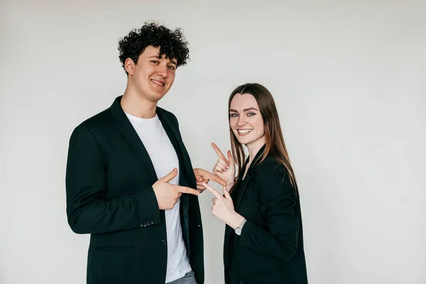 Stylish smiling couple posing and wearing elegant black blazers and accessories for men and women, white background. Fashion style catalog of clothes for business people, trends of formal wear — Stock Photo, Image