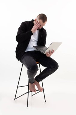 Endişeli ve meşgul bir adam dizüstü bilgisayar kullanıyor, internette çalışıyor. İş adamı başarısı, yönetici işi. Kablosuz cihaz, uzaktan kumanda.