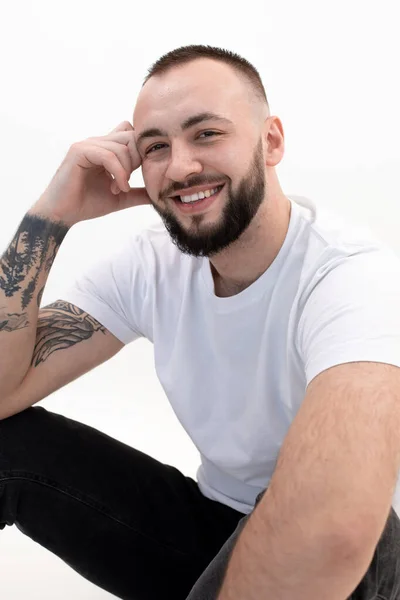 Vertical tattooed laughing handsome brunette man sitting in studio. Male hair loss problem. After transplanting. Closeup — Foto Stock