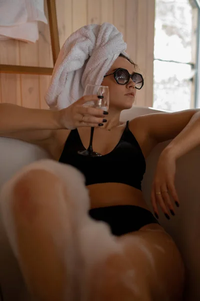 Hermosa joven toma tratamientos SPA para el cuidado del cuerpo y el cabello, relajándose con una copa de vino. Materiales de madera. Descanse en hotel de montaña. Estilo de vida saludable. Lujo y placer. —  Fotos de Stock