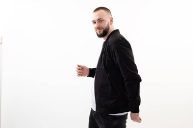 Gülümseyen, kendine güvenen esmer adam kameraya bak, poz ver, stüdyoda beyaz arka planda dolaş. Elinde bir şey tut.