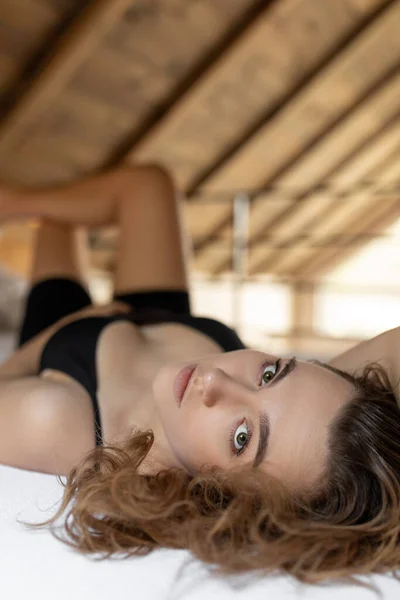 Fechar - até retrato de mulher bonita jovem que se deita na cama e olha para a câmera. Descanso e relaxamento. Emoções positivas. Materiais naturais. Beleza e juventude. Estilo de vida. — Fotografia de Stock