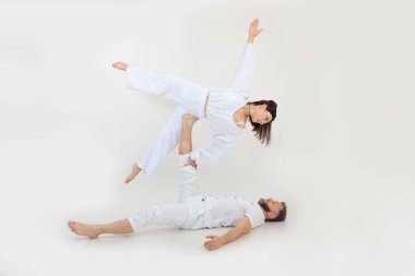 Erkek ve kadın, aile spor egzersizleri, fitness ve akrobatik yoga yapar. Ruhanilik ve zen meditasyonu. Bacağa tutunarak