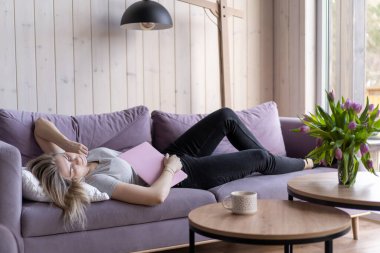 Uyku problemleri. Pembe tişörtlü ve kot pantolonlu güzel sarışın evinde elinde dizüstü bilgisayarla uyuyakaldı. İnternette evde çalışıyorum. Hafta sonu. Fazla mesai. Tükenmiş. Yorgunluk. 